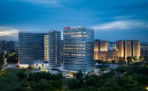 un gruppo di edifici alti in una città di notte di Hampton by Hilton Nanjing Xianlin University Town a Nanjing