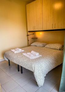 a bedroom with a bed with two towels on it at Collina del Sole in Letojanni