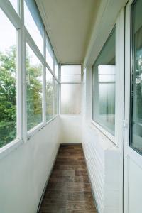 un corridoio vuoto con finestre e pavimento in legno di 2 кімнатні квартири на Каштановій Алеї. Мережа AlexApartments. Безконтатне заселення 24/7 a Poltava