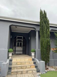 a blue house with a staircase and a gate at Michu Guest house in Cape Town