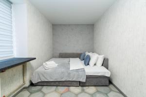 una piccola camera da letto con letto e cuscini blu di 2 кімнатні квартири на Каштановій Алеї. Мережа AlexApartments. Безконтатне заселення 24/7 a Poltava