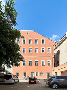 a large brick building with cars parked in a parking lot at Modern eingerichtete Wohnung im Stadtzentrum Zittau kostenloser Parkplatz in Zittau