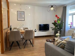 a living room with a couch and a dining room table at Modern eingerichtete Wohnung im Stadtzentrum Zittau kostenloser Parkplatz in Zittau