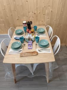 a wooden table with plates and utensils on it at Appartement plein sud, Val Thorens Centre in Val Thorens