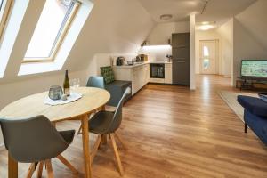 a kitchen and living room with a table and chairs at Winzerlodge, Wohnung Hatzelberg in Gleiszellen-Gleishorbach