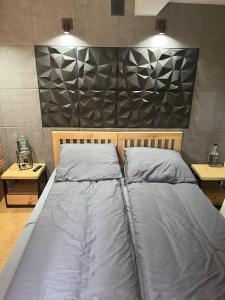 a large bed in a bedroom with two tables at Apartament ORANŻERIA in Kielce