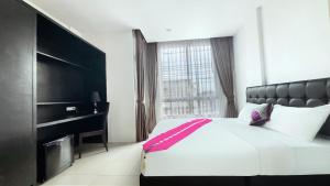a bedroom with a large bed and a large window at Vi Stay in Phuket
