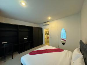 プーケットタウンにあるVi Stayのベッドルーム1室(白いベッド1台、赤い毛布付) +1枚の写真