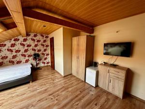 a bedroom with a bed and a tv on the wall at Kalina in Łeba