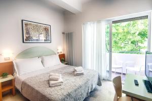 sypialnia z łóżkiem i dwoma ręcznikami na nim w obiekcie Albergo Villa Lucia w mieście Bellaria-Igea Marina