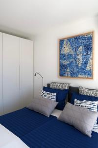 a bedroom with blue and white pillows on a bed at Art Villa Malija in Portorož
