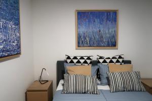 a bedroom with two beds and a painting on the wall at Art Villa Malija in Portorož +28 photos