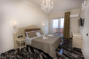 a bedroom with a large bed and a chandelier at Hotel Terrazzo Sul Mare in Tropea