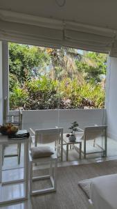a living room with a large window with a table and chairs at Saffron Robes Living in Hikkaduwa