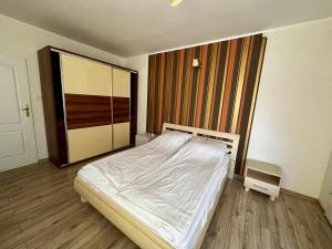 a bedroom with a white bed and a large mirror at Kalina in Łeba