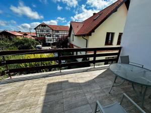 a balcony with a table and a fence at Kalina in Łeba +10 photos