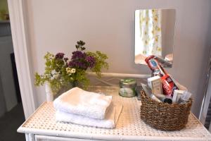 a dressing table with towels and a mirror and flowers at Applegarth House in Lockerbie +30 photos