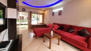a living room with a red couch and a table at Heritage Exotica Villa 3BHK JAQK Holidays in Arpora