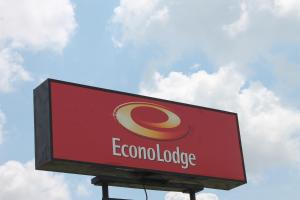 a red sign for a corona lodge with a cloudy sky at Econo lodge Kennett in Kennett