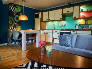a living room and kitchen with a couch and a table at BnB De Peelvos in Deurne