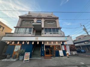a building on a street with signs in front of it at HOSTEL OE in Yoshinogawa