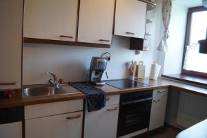 a small kitchen with a sink and a microwave at Ferienwohnung KaFaHof in Waldenstein
