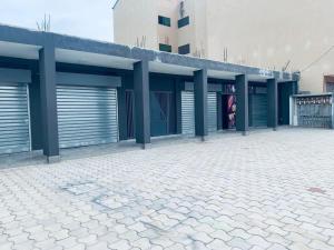 a building with garage doors and a brick patio at Marie in Grand-Bassam