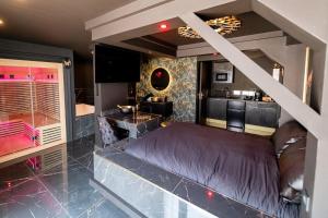a bedroom with a large bed and a kitchen at Suite D&S Luxury Room in Firminy
