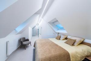 a bedroom with a large bed and a chair at Loft Exclusif in Knokke-Heist