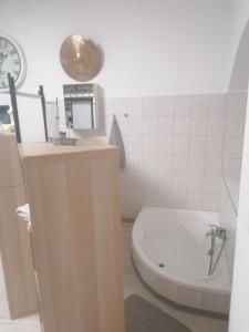 łazienka z toaletą, umywalką i zegarem w obiekcie Újkapu Sunshine Apartments w Győr +31 zdjęć