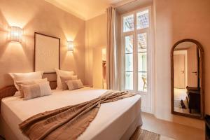 Un dormitorio con una cama con espejo y una ventana. en Magnificent apt - 2BR-6P - Heart of Saint-Tropez, en Saint-Tropez