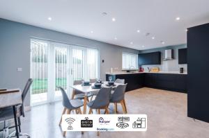 a kitchen and dining room with a table and chairs at Spacious Detached House Driveway By Harperletting ShortLets & Serviced Accommodation Hawarden With Long or Short Stays Disc options in Ewloe