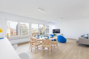 een woonkamer met een tafel, stoelen en een bank bij Maison Anna by Exclusive-Stays in Oostende
