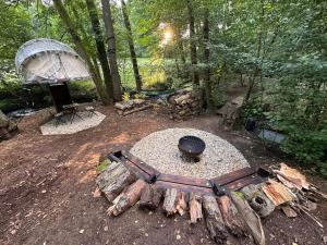 eine Feuerstelle mit Grill und ein Zelt im Wald in der Unterkunft Bublina in Trutnov