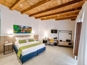 a bedroom with a bed and a desk in a room at Thaleia Dimora di Pregio in Cefalù