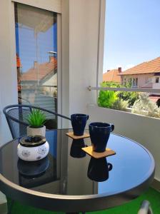 a glass table with two vases on top of it at Riverside LUX Apartment in Pirot