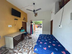 un homme assis sur un bureau dans une chambre dans l'établissement Hello India home stay, à Khajurâho