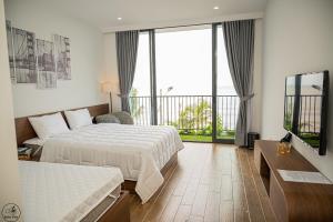 a hotel room with two beds and a balcony at AnAn Villa - Hải Tiến in Nam Khê