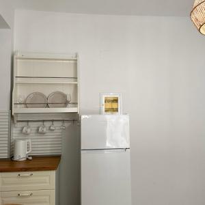 a kitchen with a white refrigerator in a kitchen at Petra Mare Apartments in Alyki