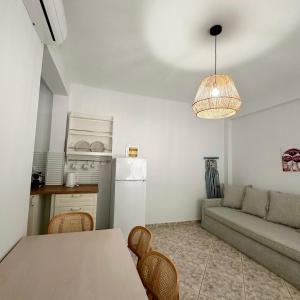 a kitchen and living room with a table and a couch at Petra Mare Apartments in Alyki