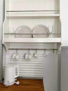 a kitchen with a shelf with pots and pans at Petra Mare Apartments in Alyki