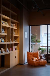 una poltrona a sacco arancione in una stanza con una libreria di 吃山02救赎青年旅店 a Chongqing