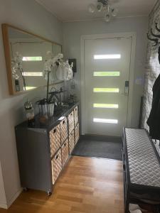 bagno con tavolo da trucco, specchio e porta di Mysigt rum i trevligt hus a Taberg