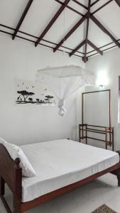 1 dormitorio con 1 cama con lámpara de araña en Imen villa, en Hikkaduwa