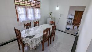 Un comedor con una mesa y sillas blancas. en Imen villa, en Hikkaduwa