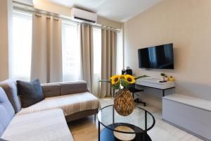 a living room with a couch and a tv at Tsimiski double suites #8 in Thessaloniki