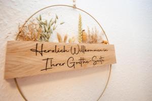 a wooden sign hanging on a wall with plants at Exklusive Goethe-Suite am Brocken by Meis in Wernigerode Zentral in Wernigerode