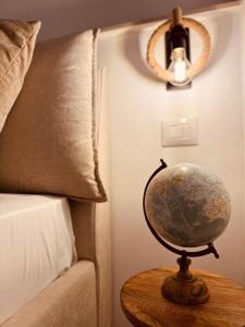 a globe on a table next to a bed at La dimora del faro in Bari