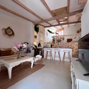 a living room with a white table and stools at Tu Casita Rural in Valdilecha