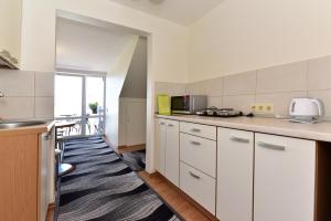 a kitchen with white cabinets and a counter top at Vilaverona in Palanga